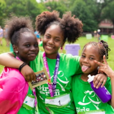 Three Girls on the Run participants smile while showing off 5K medals