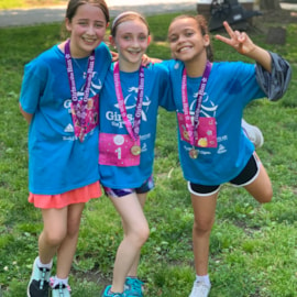 Smiling Girls on the Run participants embracing each other after a site-based 5K
